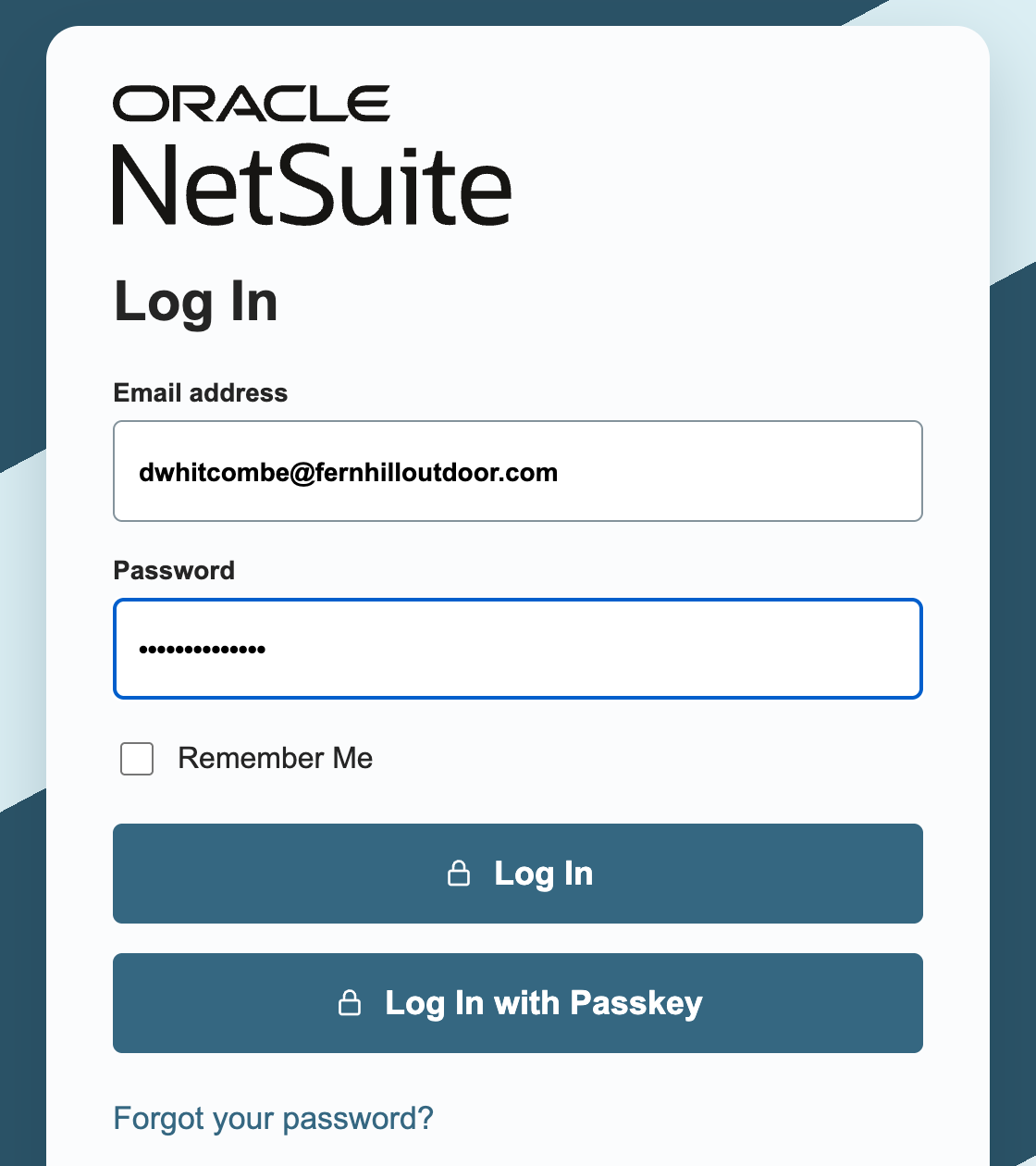 NetSuite Log In page with dwhitcombe@fernhilloutdoor.com in Email address and a masked password in Password, above the Log In and Log In with Passkey buttons.